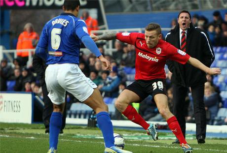 Craig Bellamy takes on Curtis Davies with his manager looking on in the background - the man with the dodgy knees played every minute of the holiday period as his influence reached end of 2010/11 levels.